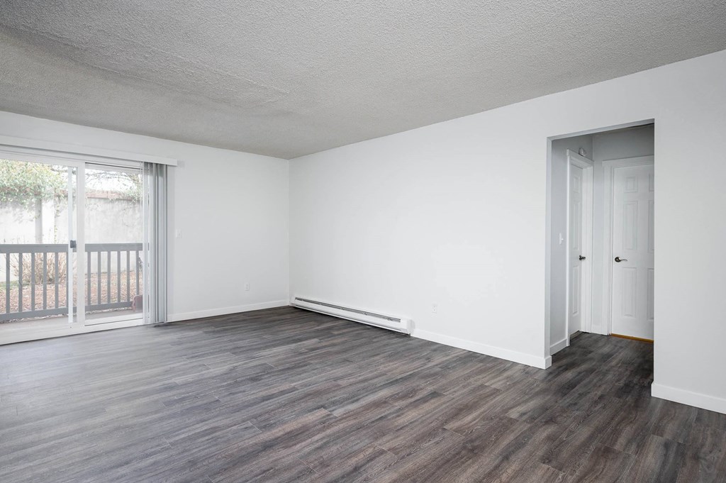 an empty living room with white walls and wood floors